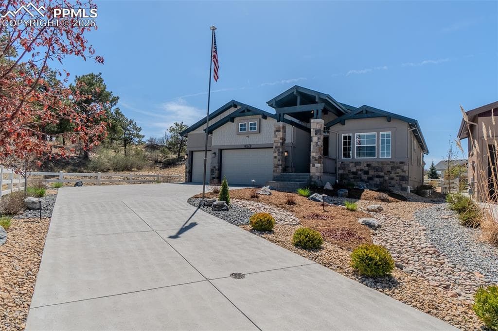 Craftsman-style exterior featuring stone accents, a covered entry, three-car garage and an impressive Flag Pole that will stay 