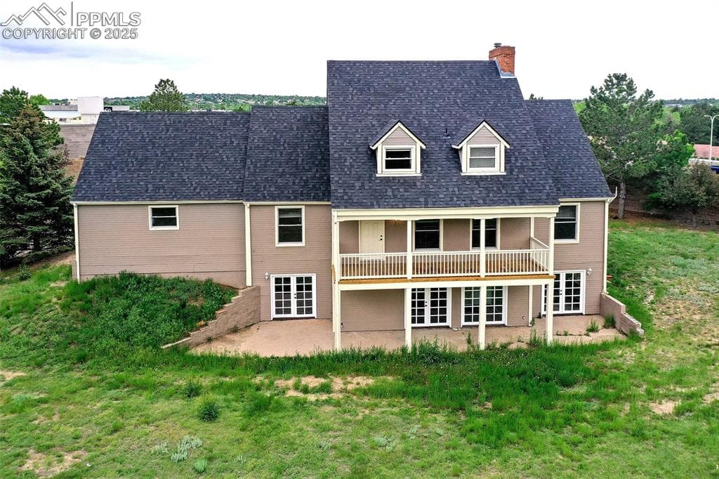 Back of property featuring a patio area, a chimney, french doors, and roof with shingles
