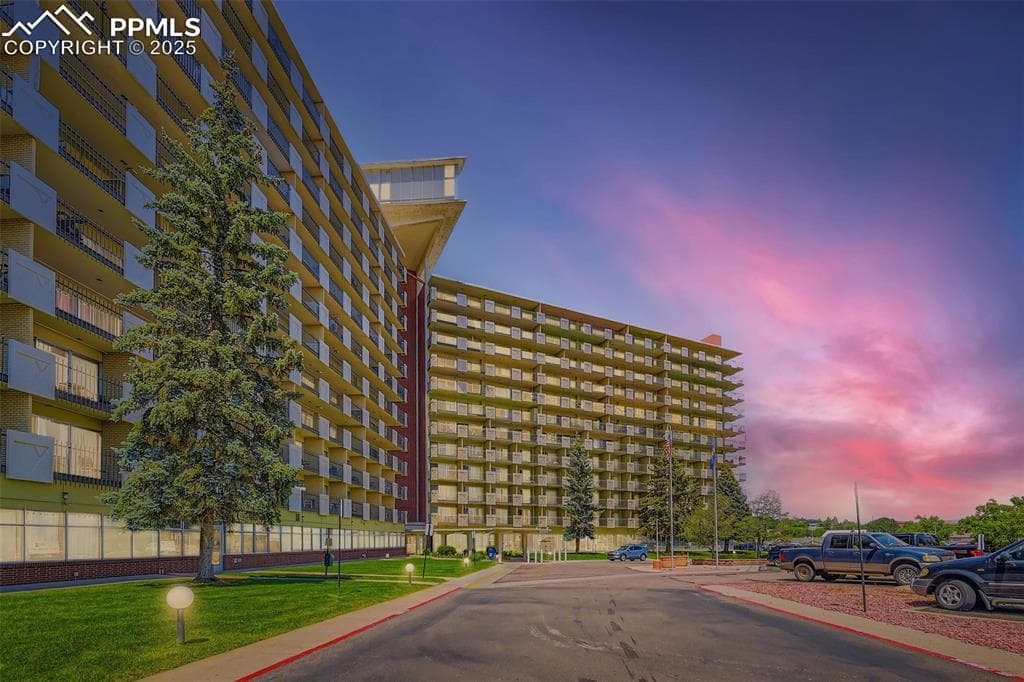 Property at dusk featuring a view of apartment building / complex
