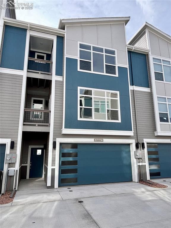 Contemporary house with driveway, an attached garage, and a balcony